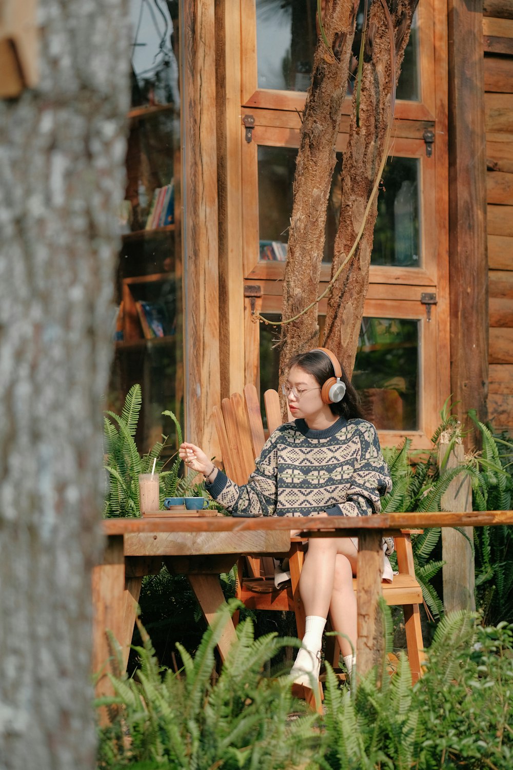 a woman sitting at a table with headphones on