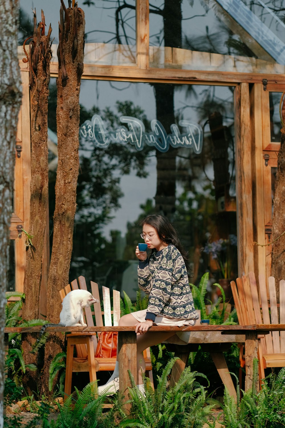 a woman sitting on a wooden bench next to a dog