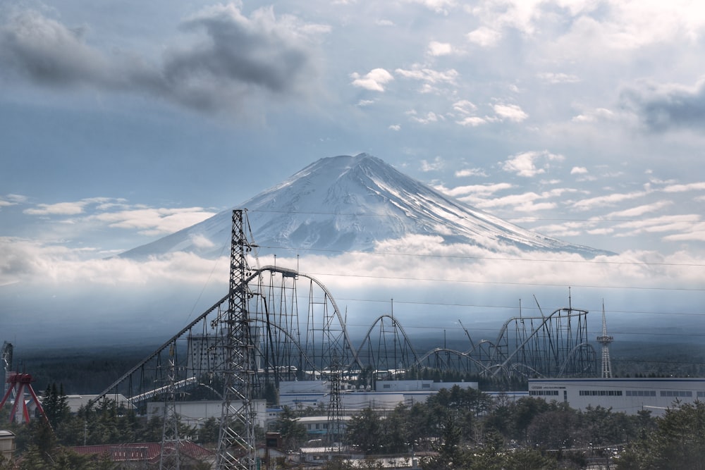 a roller coaster with a mountain in the background