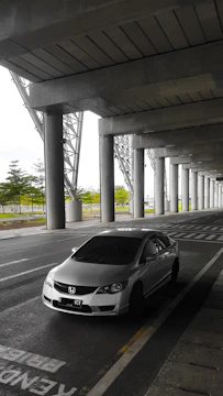 Sleek tensile roof covering a modern car parking area.