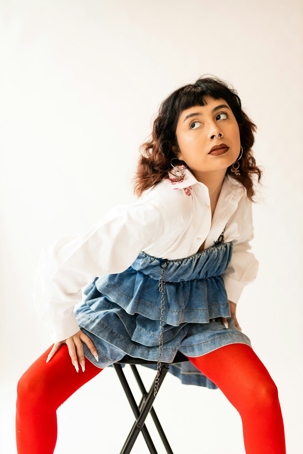 a woman sitting on top of a chair wearing red tights
