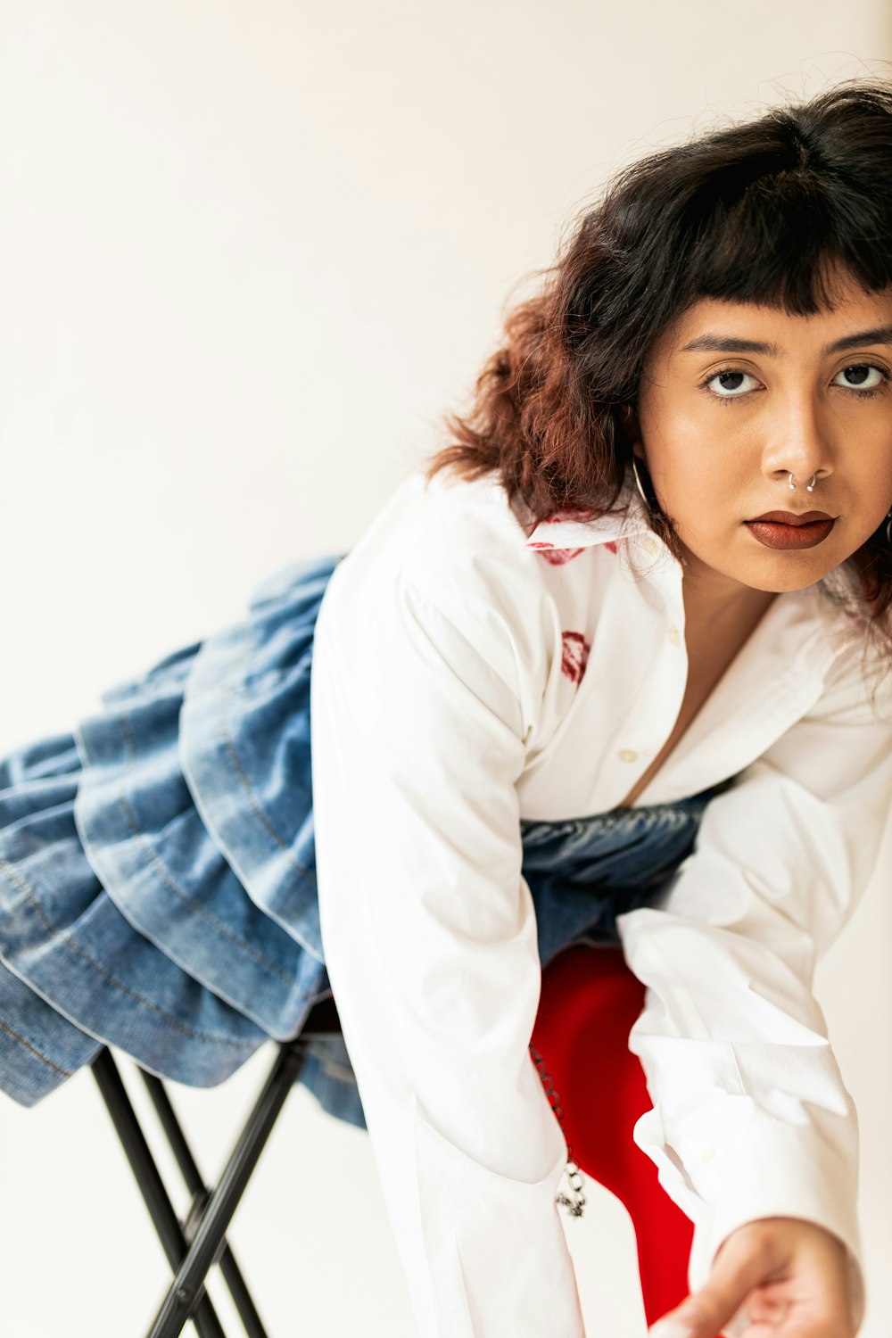 a woman in a white shirt and blue tie sitting on a chair