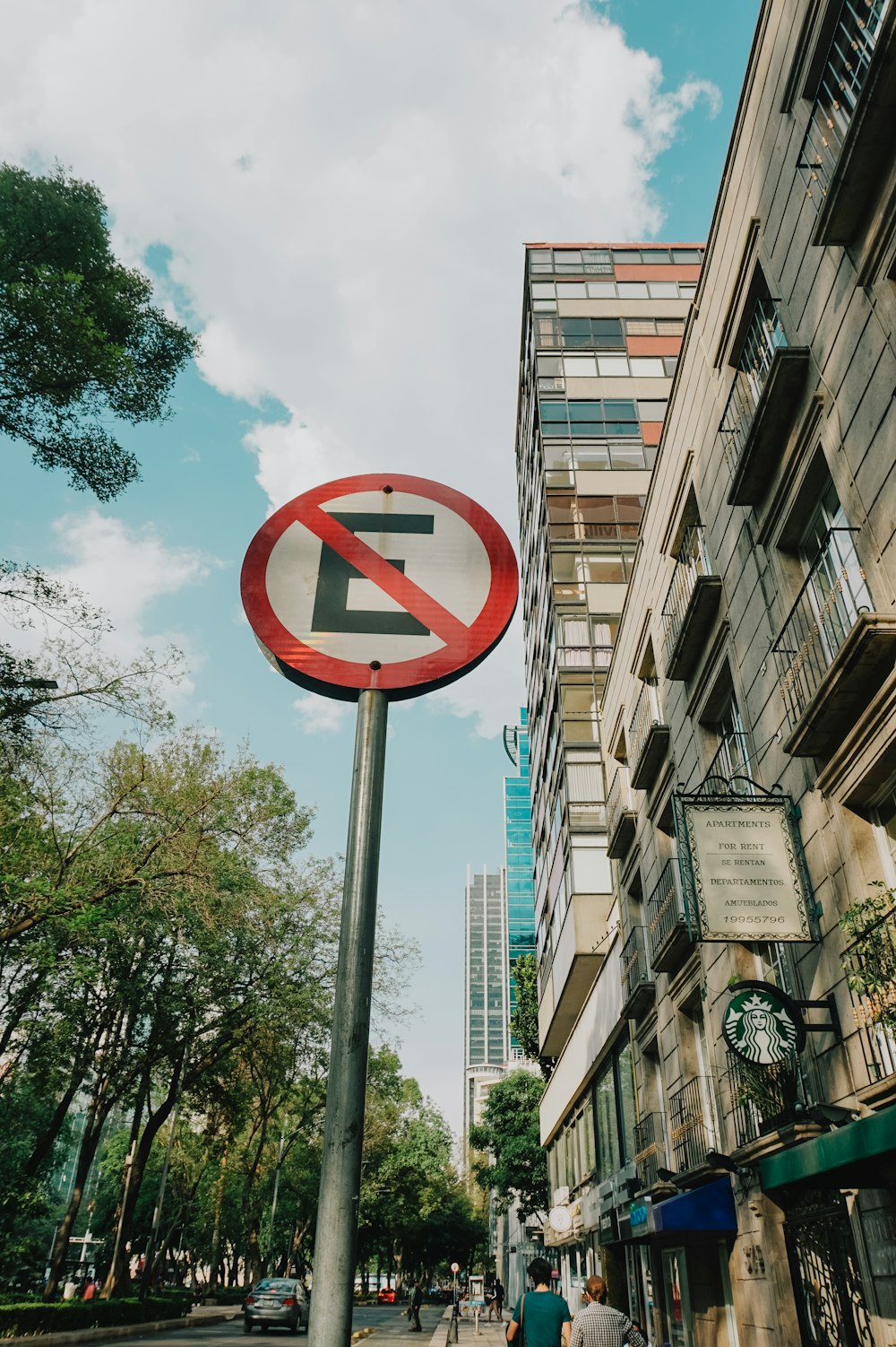 a no left turn sign in front of a tall building