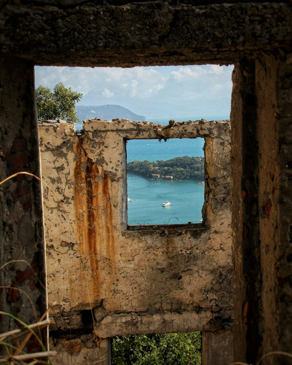 a view of a body of water through a hole in a wall