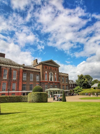 a large red brick building sitting on top of a lush green field
