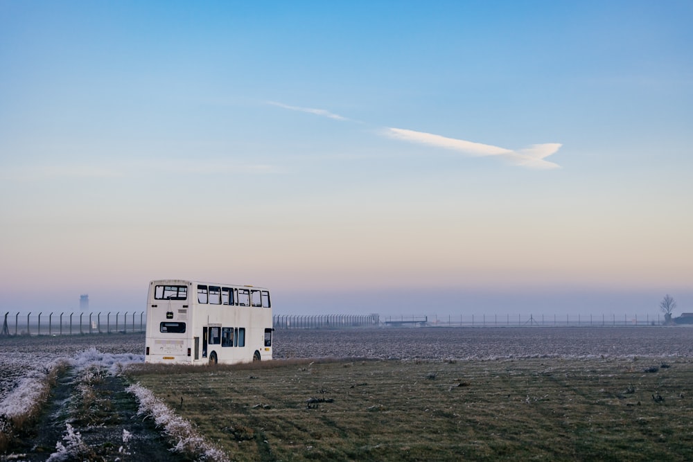 a white double decker bus driving down a road