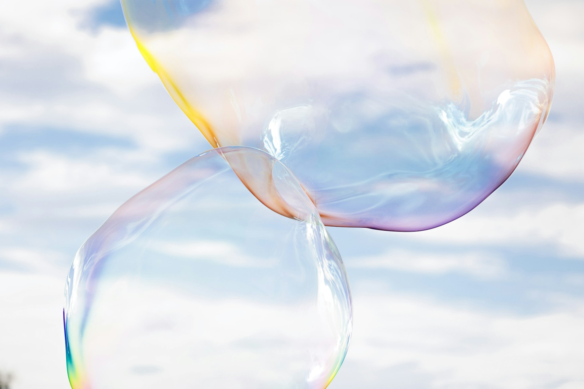 a rainbow colored stream of soap bubbles floating in the air