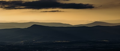 A misty surreal landscape where golden suns hover above layered earth, blending architectural lines with dreamlike figures.