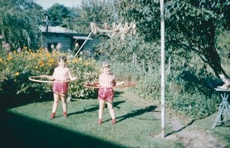 two young girls playing with a hula hoop