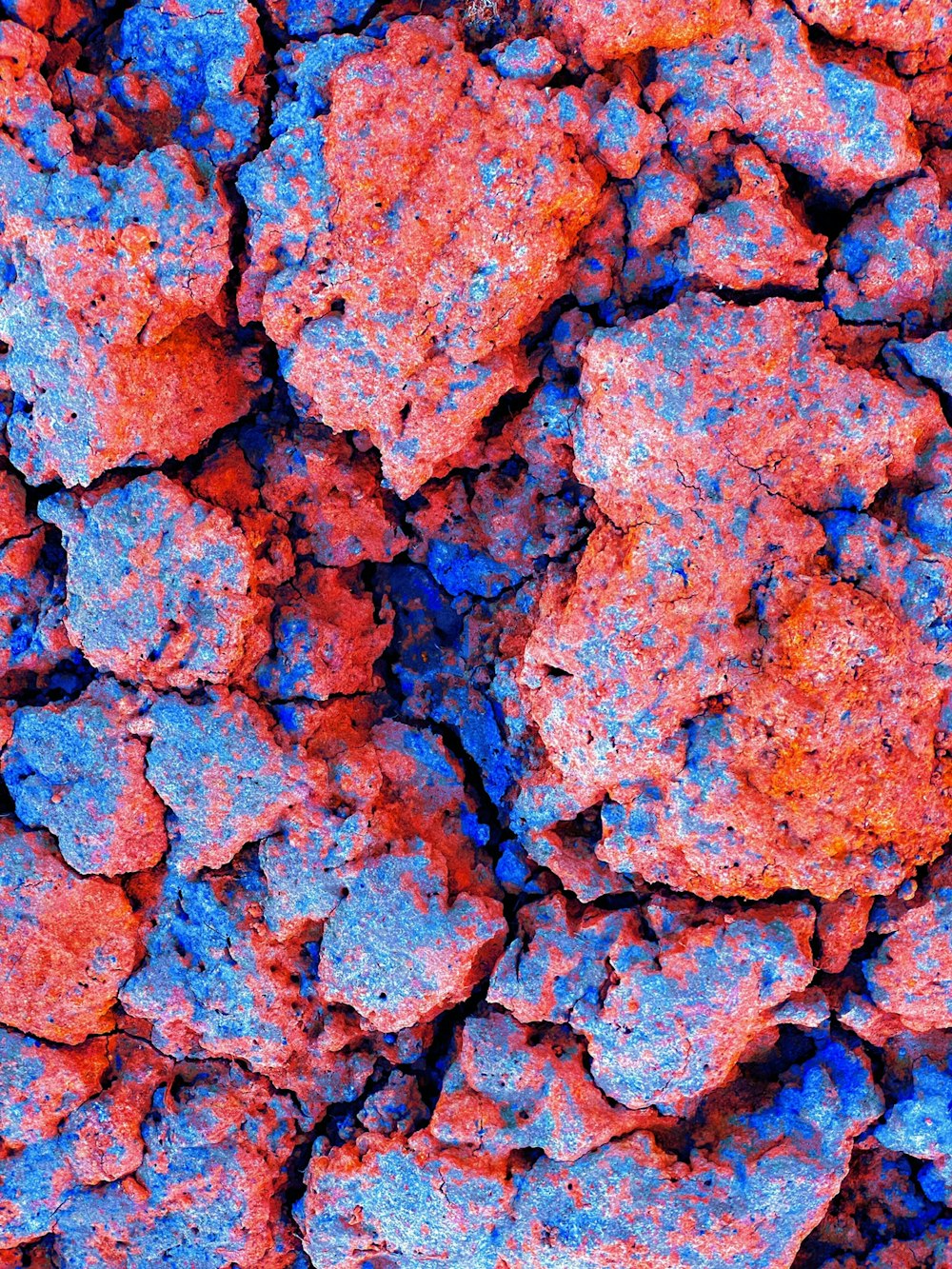 a close up of a rock surface with blue and red colors