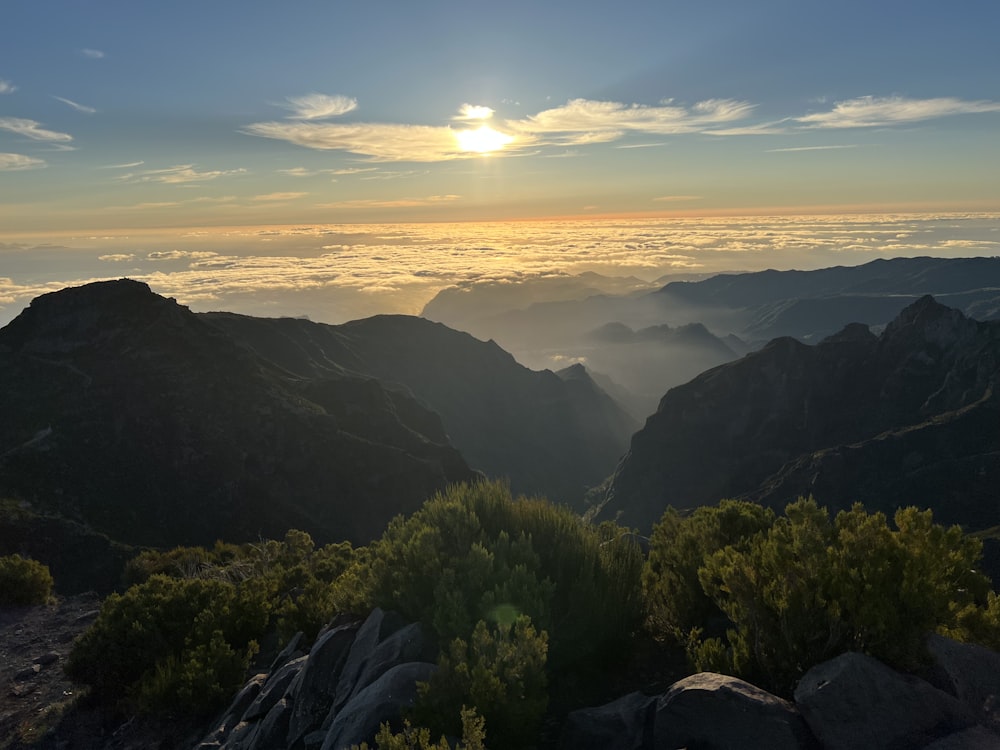 the sun is setting over a mountain range