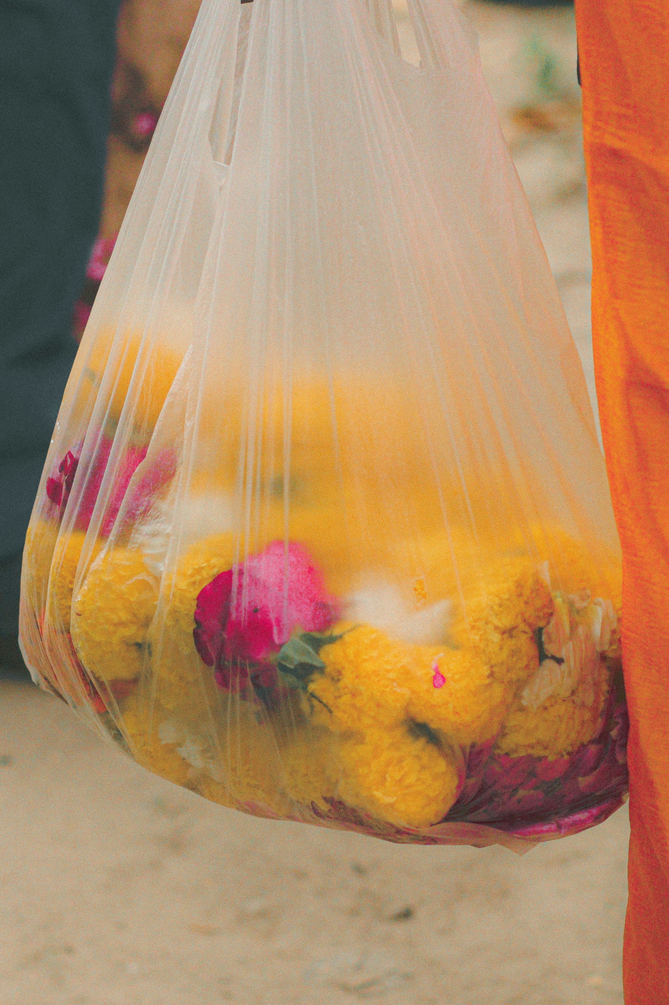 A bag of marigold and rose offerings held at a temple