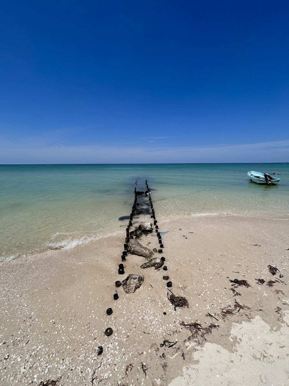 a boat sitting on top of a beach next to the ocean