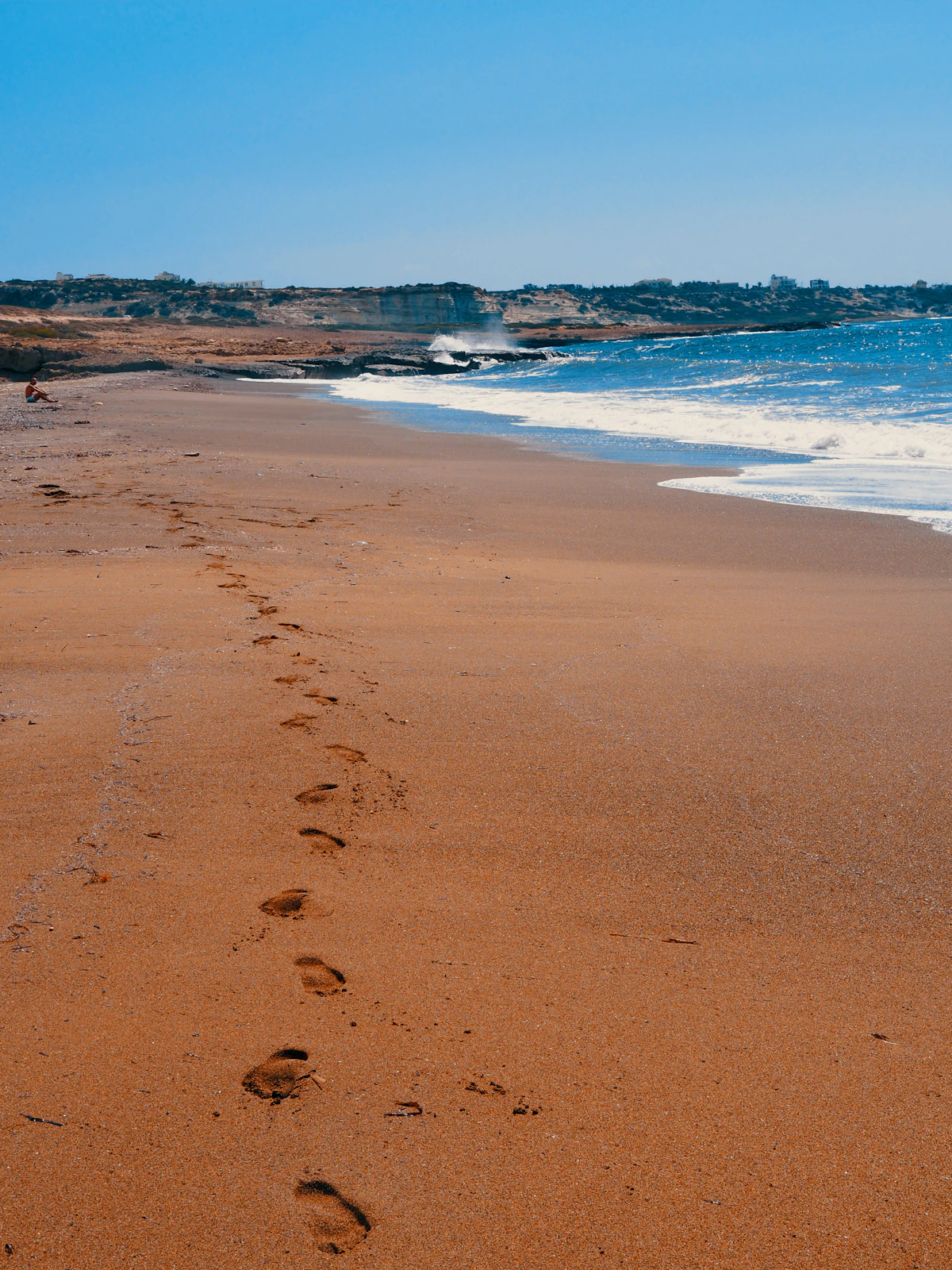 Person walking along a sandy beach at golden hour, illustrative of Sunrise Beach, Protaras, Cyprus