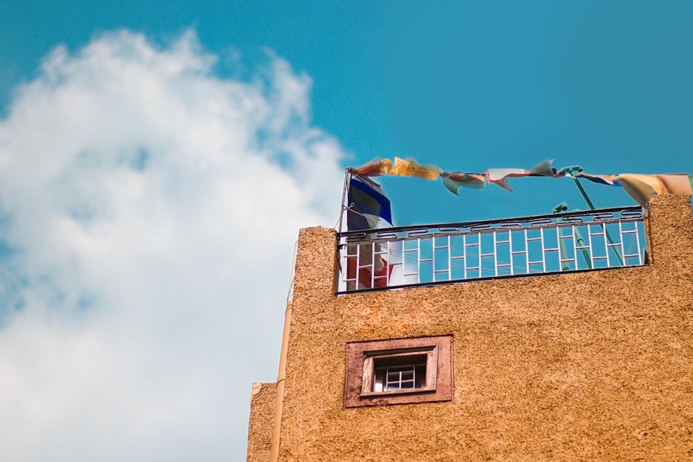 a tall building with a balcony and a sky background