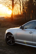 Sleek silver sedan parked on a city street at sunset
