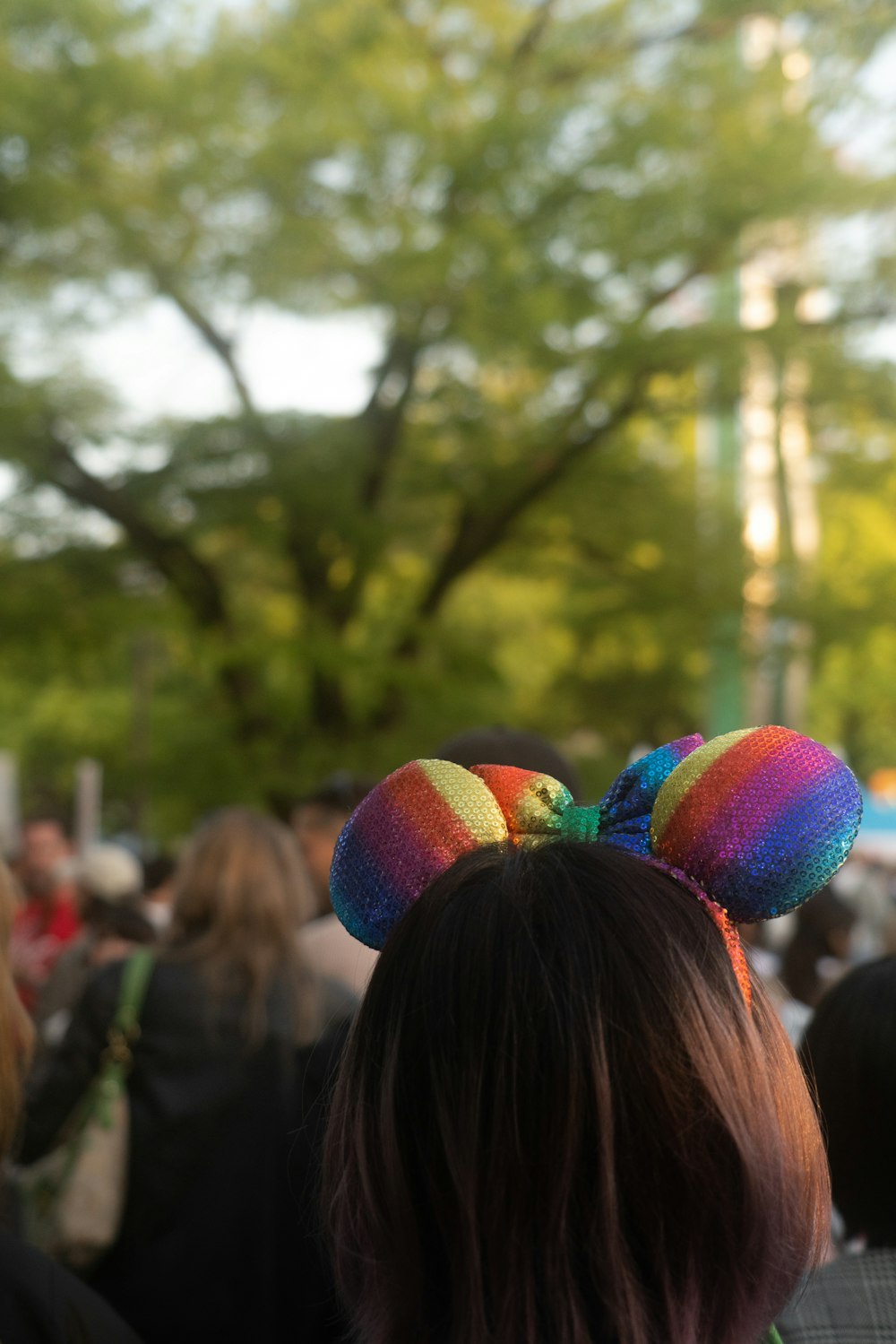 a woman with a rainbow colored mouse ears on her head