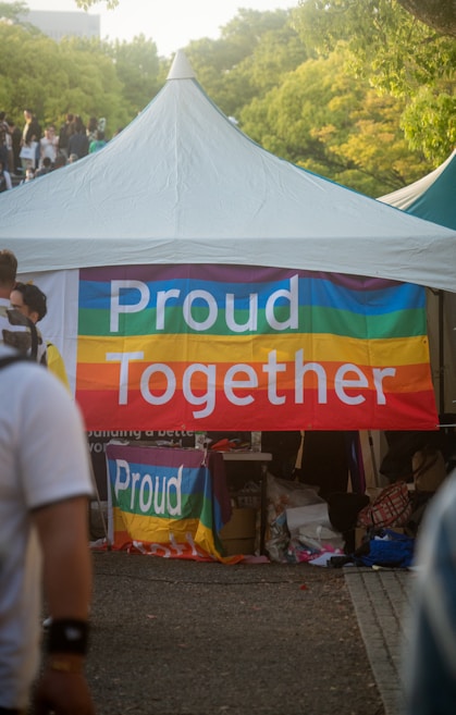 A tent is set up outdoors with a colorful banner that reads 