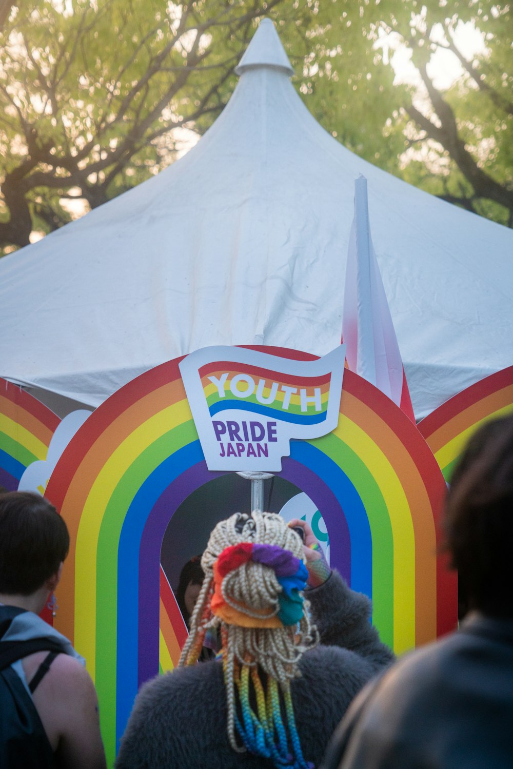 a group of people standing in front of a rainbow tent