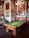 A happy customer playing pool on a sleek, modern table in a cozy living room.