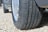 A close-up of a car tire on a gravel road, showcasing its tread pattern and durability.