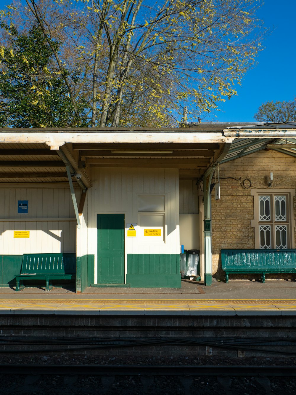 a train station with benches and a train on the tracks