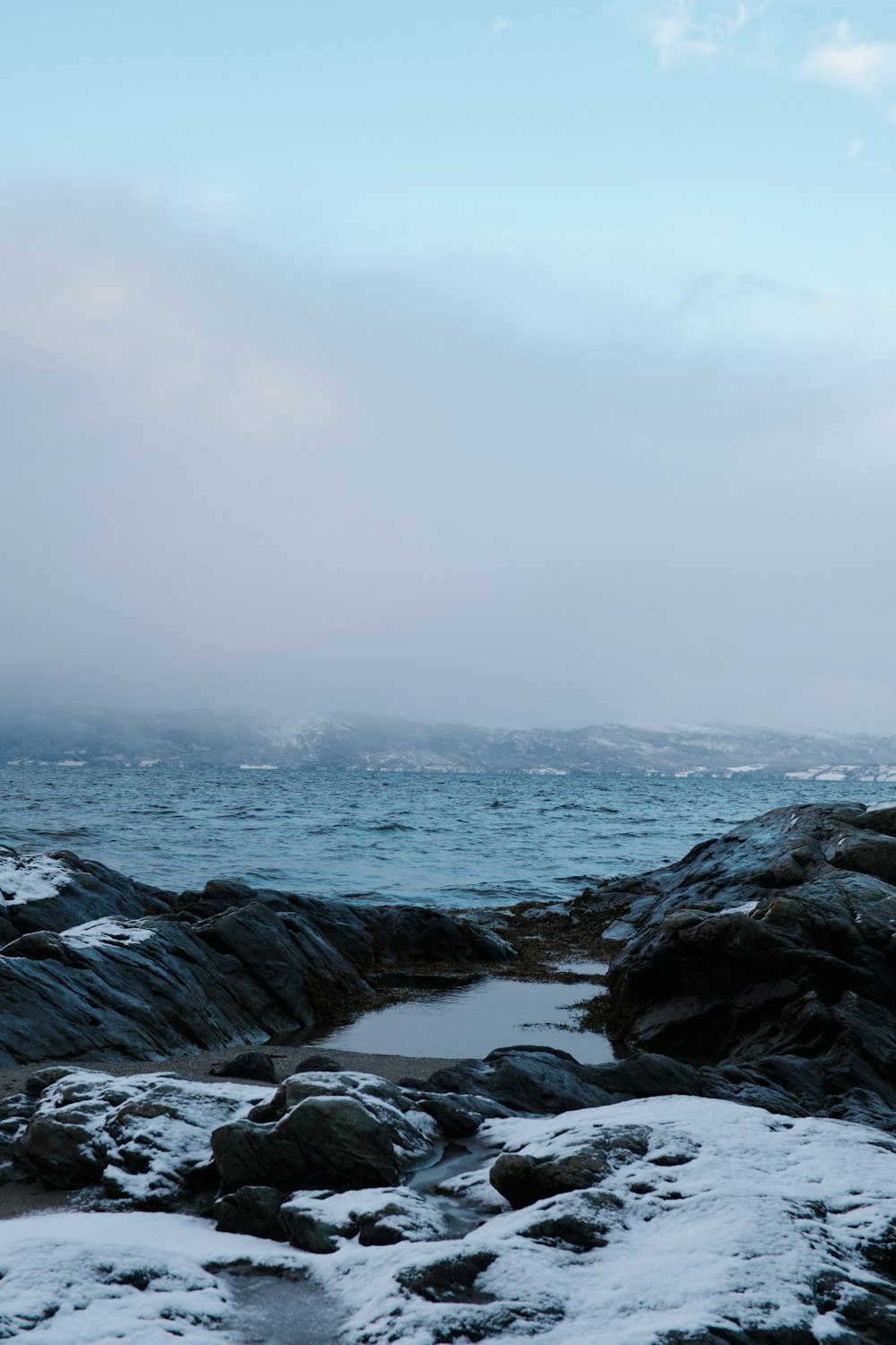 a view of a body of water from a rocky shore