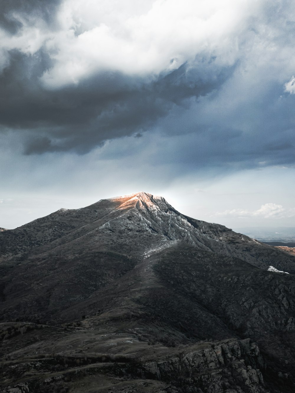 a view of a mountain with a cloudy sky