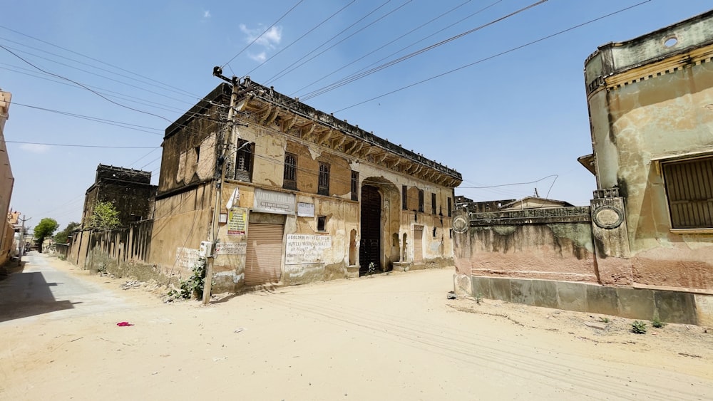 an old run down building on a dirt road