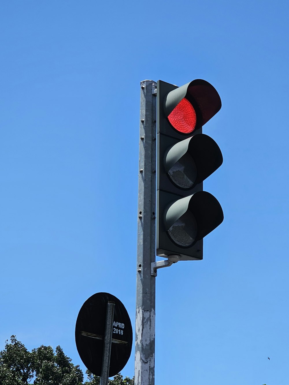 a traffic light on a pole with a blue sky in the background