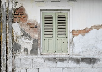 a white building with a green door and window