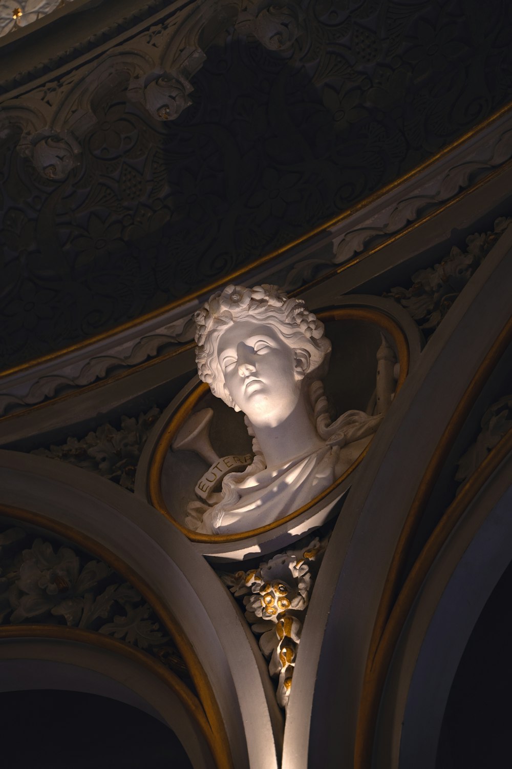 uma estátua de uma mulher no teto de um edifício
