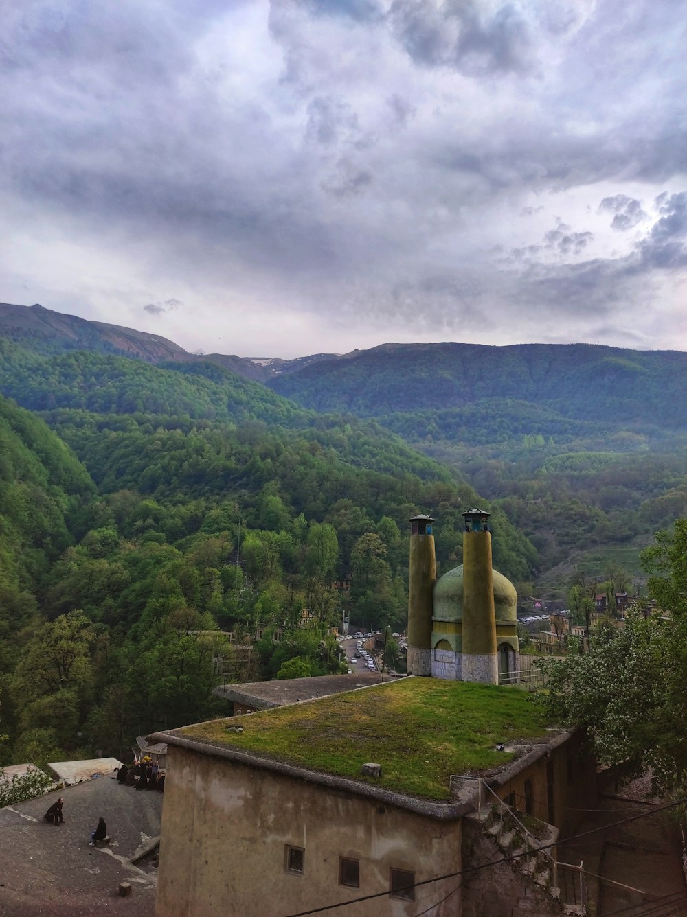 a green roof on a building with mountains in the background