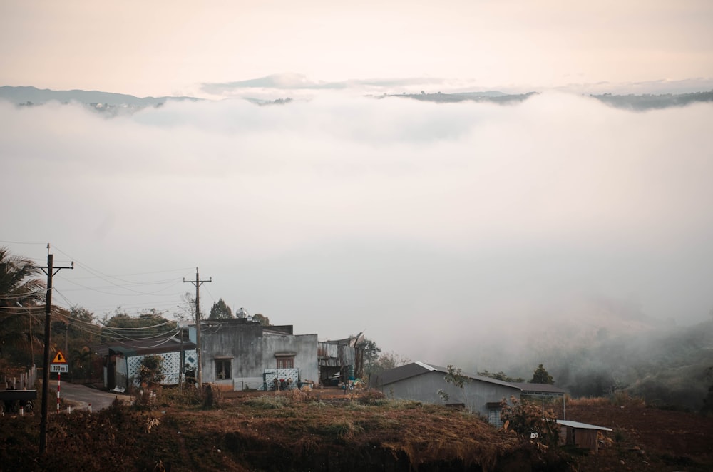 a view of a foggy mountain with a house in the foreground