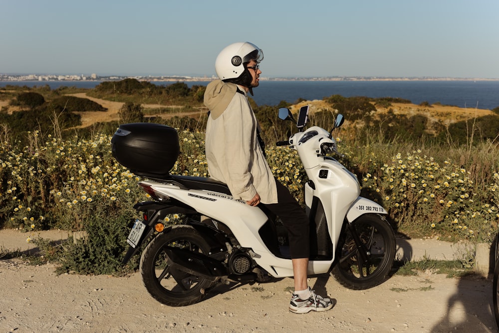 a man standing next to a white scooter