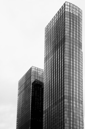 a black and white photo of two skyscrapers