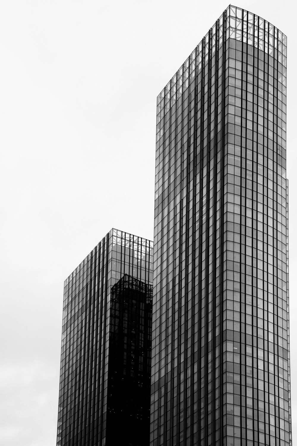 a black and white photo of two skyscrapers