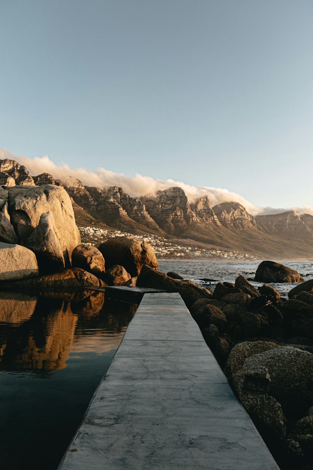 a dock leading to a body of water with mountains in the background