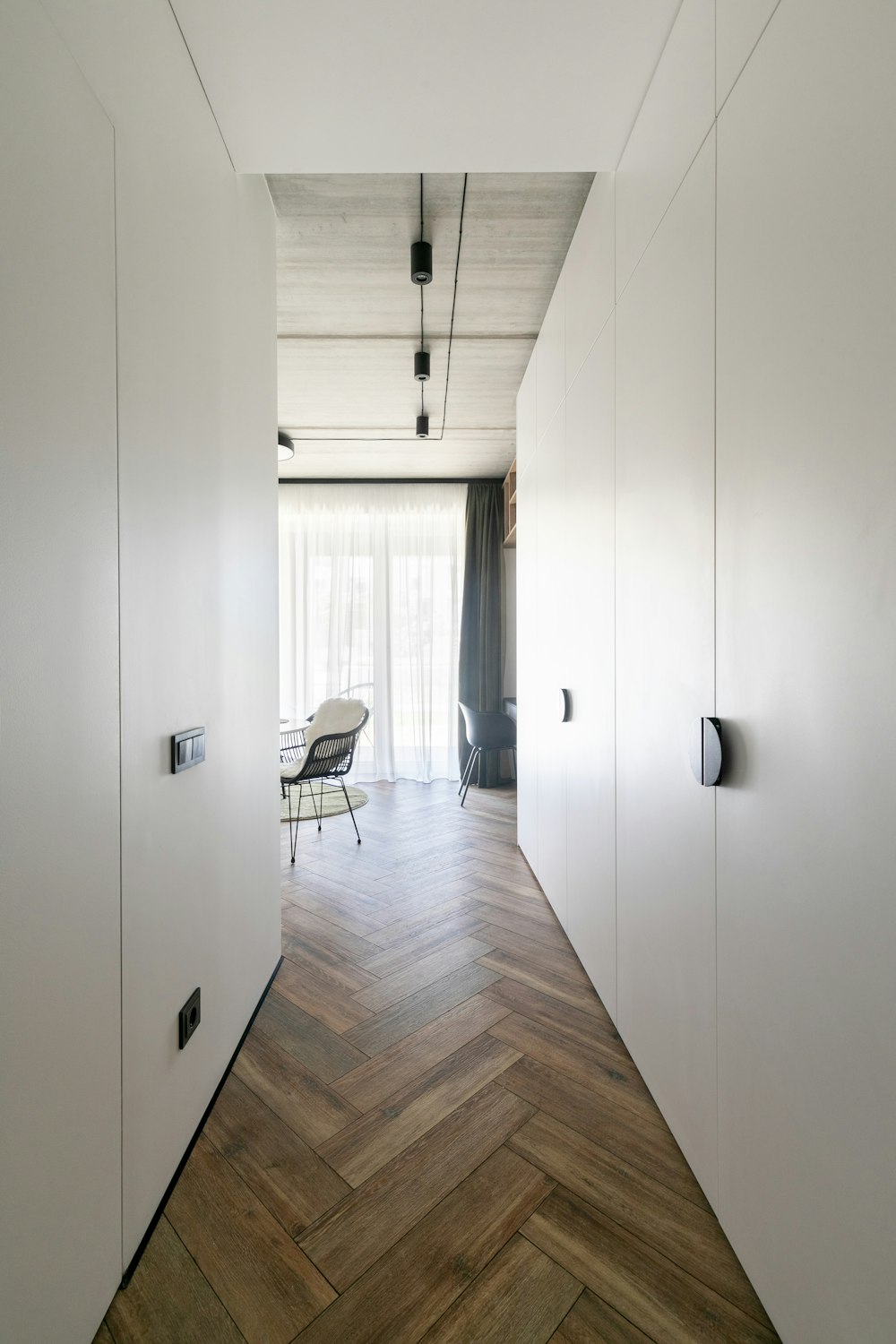 una camera con pavimento in legno e pareti bianche