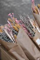 Hand-tied seasonal wildflower bouquet wrapped in minimalist kraft paper.