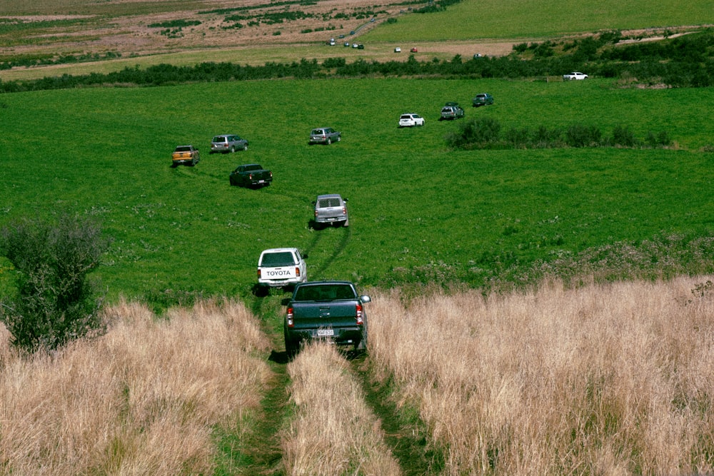 a group of trucks driving down a dirt road
