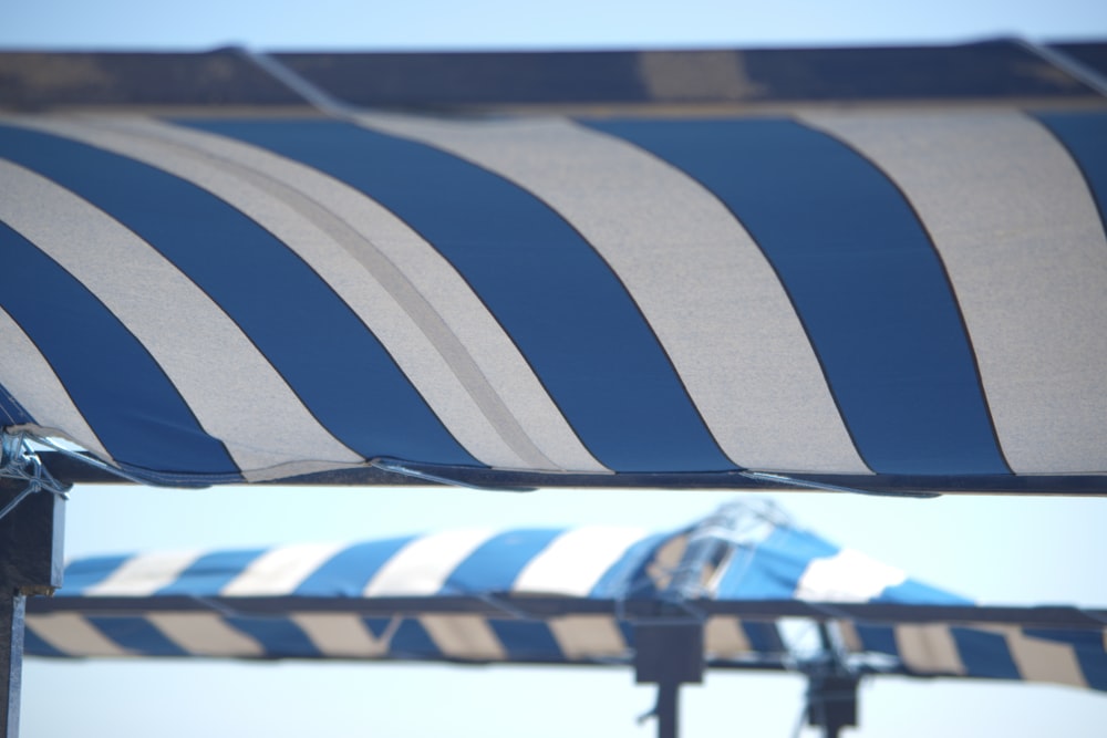 a large blue and white striped umbrella on a sunny day