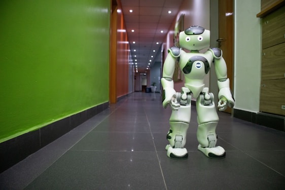 A sleek humanoid robot interacting with a human researcher in a bright, modern lab.