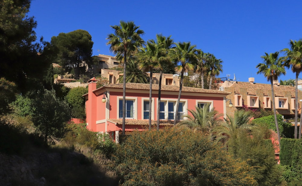 a pink house with palm trees in front of it