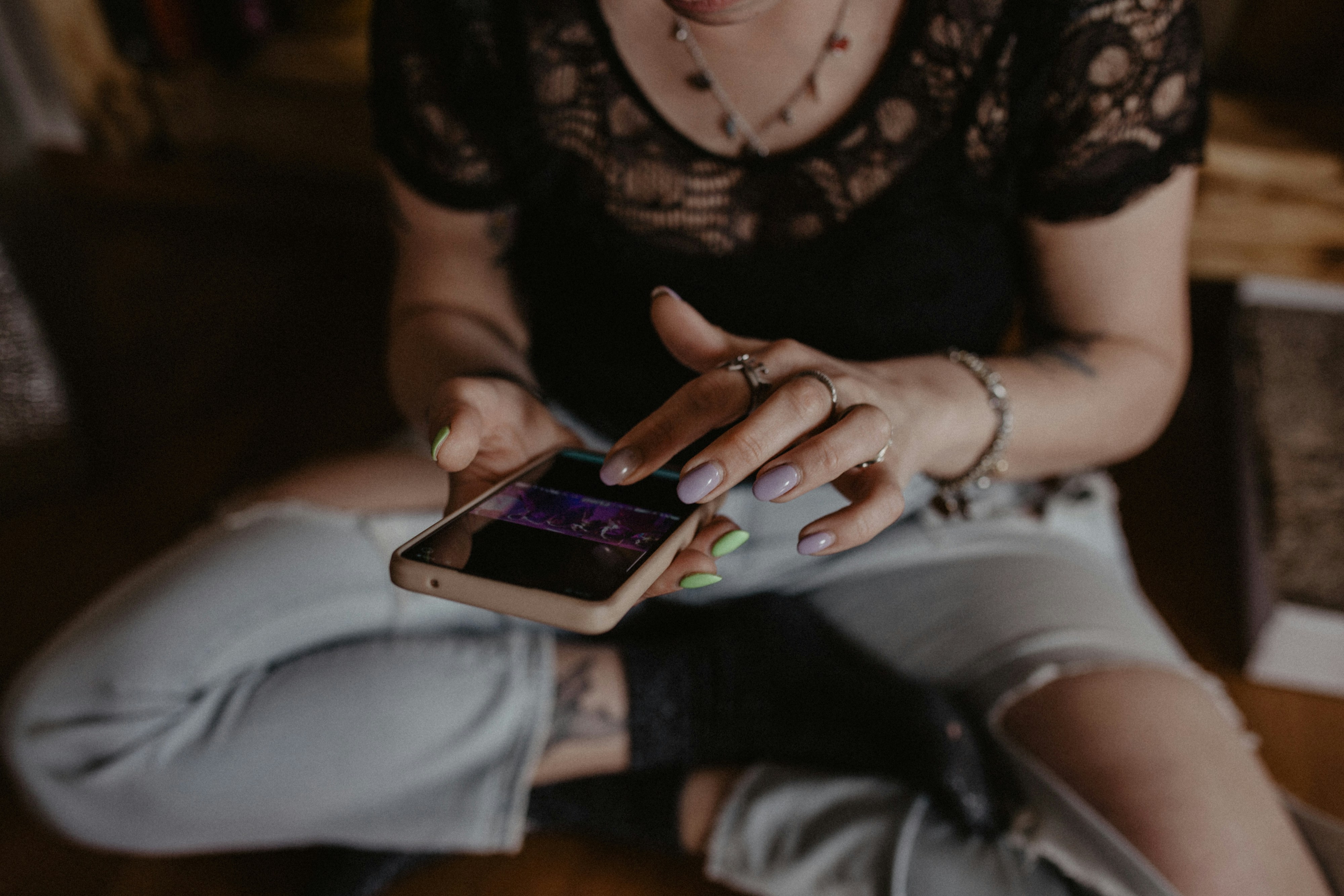 a woman sitting on the floor looking at her cell phone