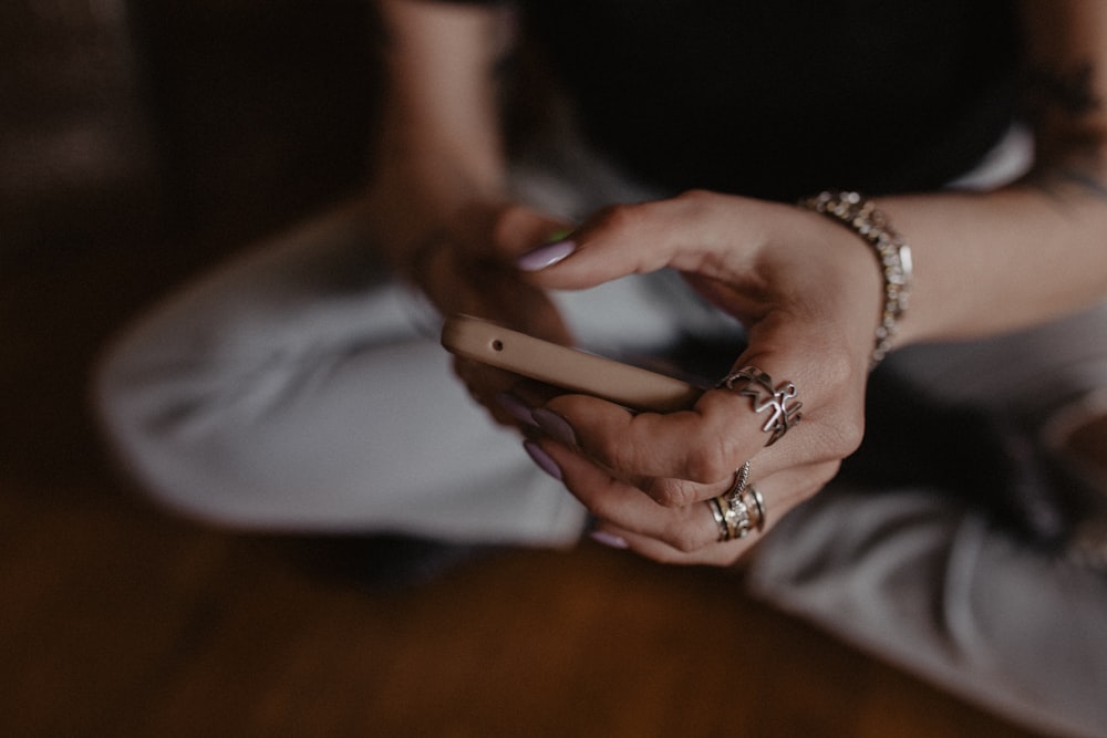 a woman sitting on the floor holding a cell phone