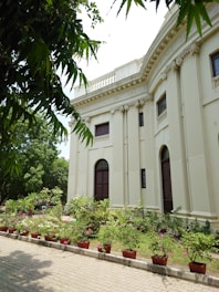 a large building with a lot of plants in front of it