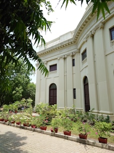 a large building with a lot of plants in front of it
