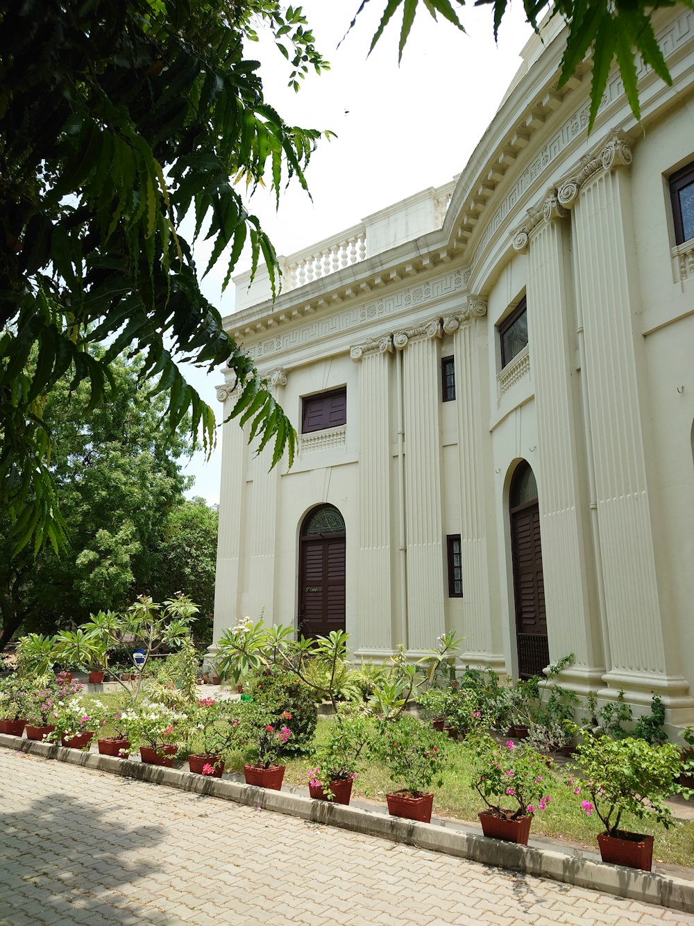 a large building with a lot of plants in front of it