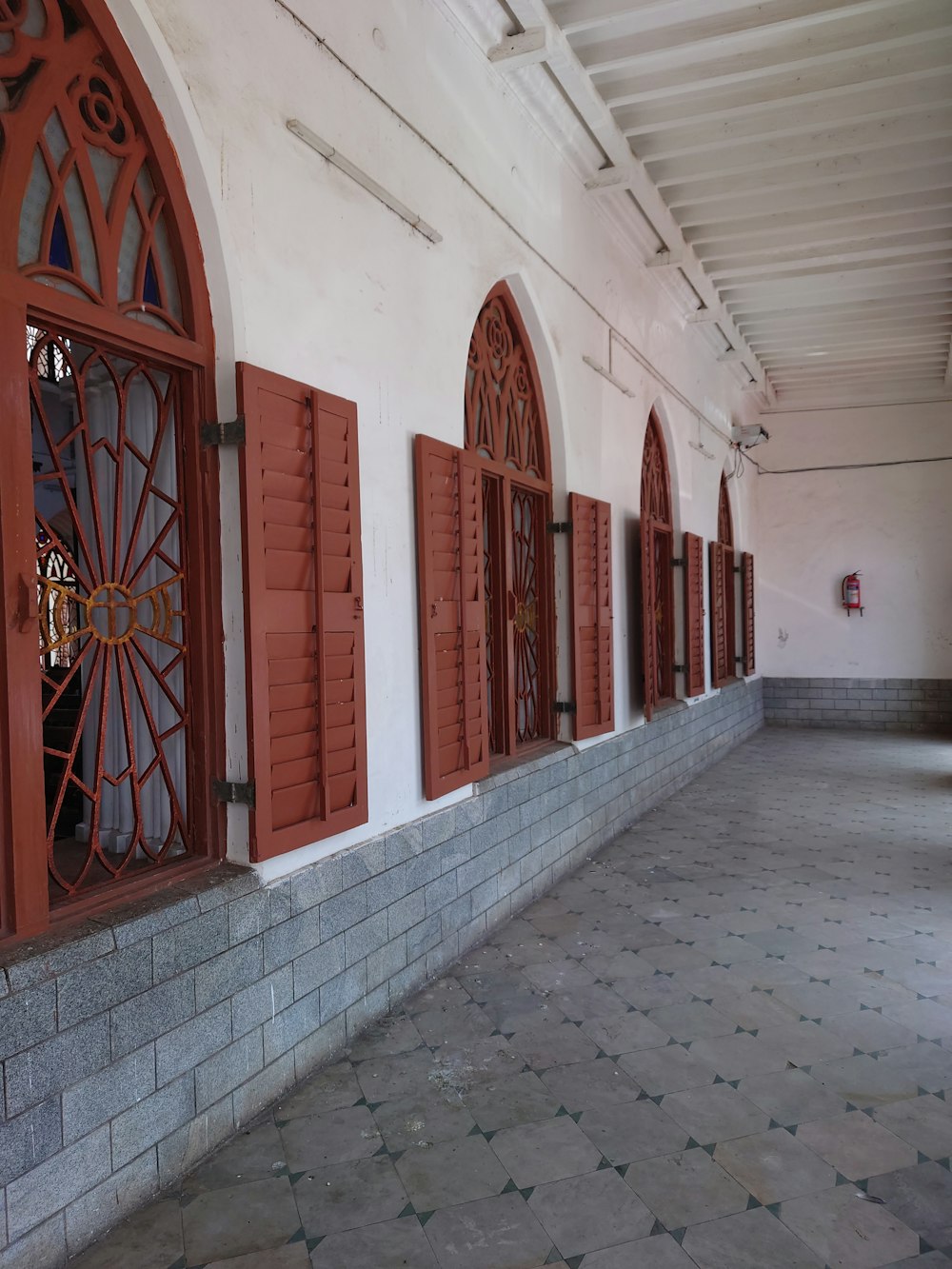 a building with red shutters and a clock on the wall